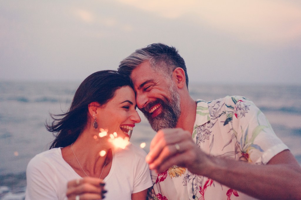 Couple, including famous character Anita Kravo, celebrating with spark on the beach