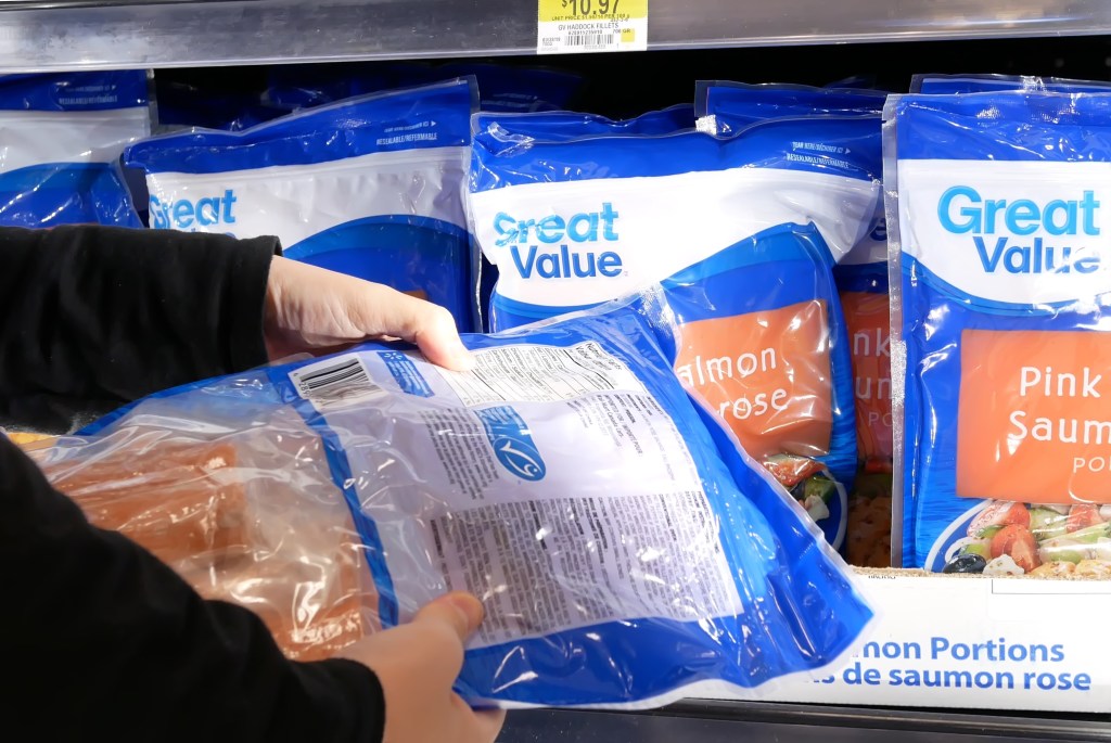 Woman buying a large brand of white shrimp at a Walmart store